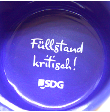 schwarze Keramiktasse SDG, Innendruck "Achtung Heißdampf", innenseite blau glänzend, Bodendruck "Füllstand kritisch!"