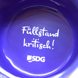 schwarze Keramiktasse SDG, Innendruck "Achtung Heißdampf", innenseite blau glänzend, Bodendruck "Füllstand kritisch!"